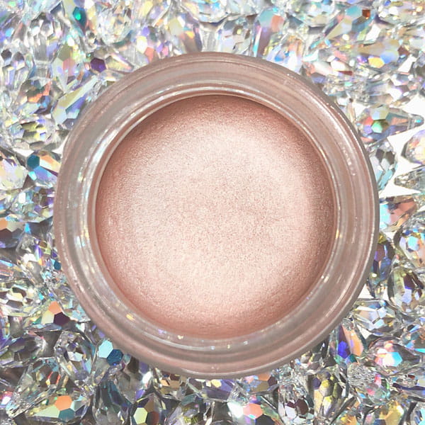 Naturalny kremowy rozświetlacz glow & beauty w delikatnym, różowo-beżowym odcieniu, umieszczony w okrągłym słoiczku.